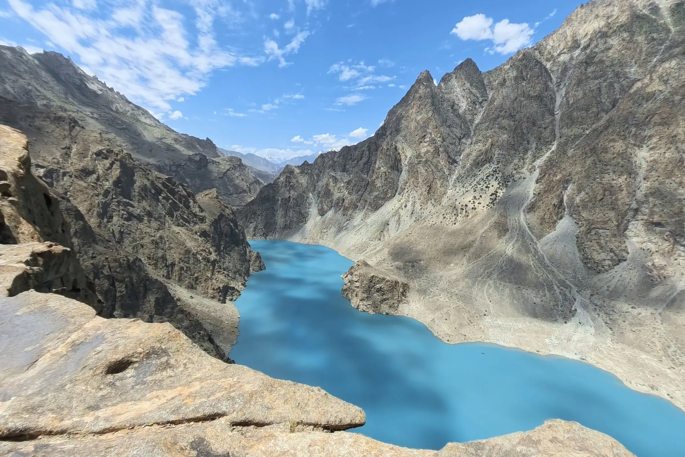 Attabad Lake far below a high rocky ridge, the kind of viewpoint a day walk from Ghulkin reaches